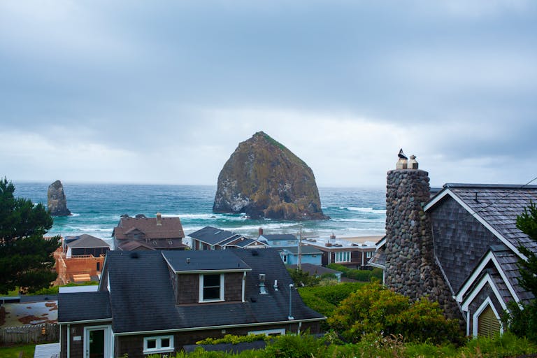 Picturesque coastal village with Haystack Rock and ocean view, capturing serene beauty of the Oregon coast.
