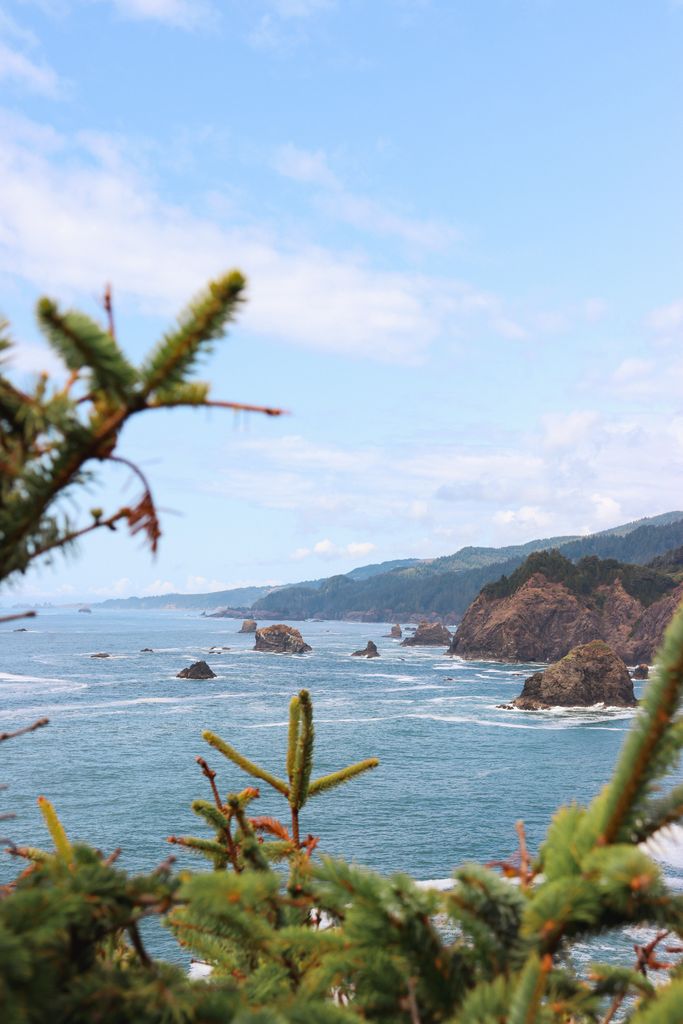 Beautiful view of the rugged Oregon coastline with waves and rocky outcrops under a clear blue sky.